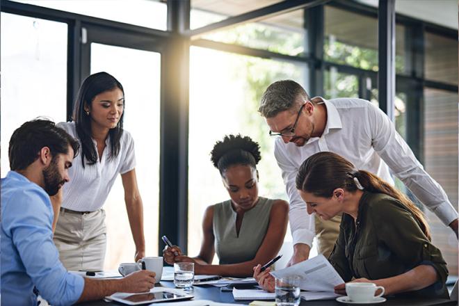 Five people around a table discussing business resources